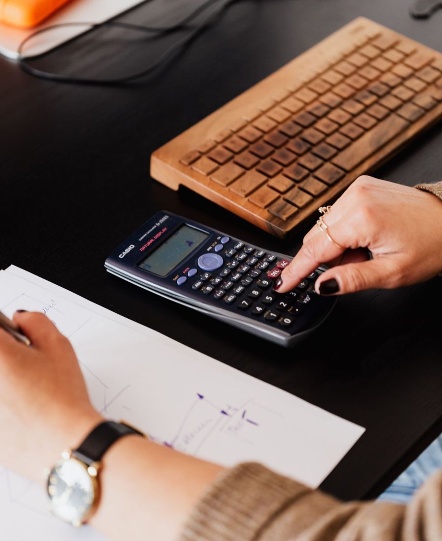 Hands working through figures with a calculator